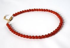 Carnelian is a lovely semi-translucent stone in a rich orangey red color.  It is highly polished for a beautiful shining quality. The stones themselves are a larger size- about 8mm around- so this is a necklace that will make a nice statement.The necklace is 15" long with a 2" extender chain, or it can be finished with two rings in the 18th Century style.  This allows you to run a ribbon of your choice through the rings and tie it tightly on the neck, like a choker, or loose so it hangs down low Red Carnelian Beaded Necklace Hand-strung, Hand-strung Red Carnelian Beaded Necklaces, Red Carnelian Hand-strung Beaded Necklaces, Red Beaded Necklaces, Carnelian Necklace, Regency Era, Carnelian Beads, Necklace Red, Necklace Beaded