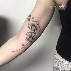 a woman's arm with a flower tattoo on the left side of her arm