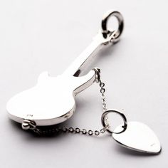 a metal key chain with a guitar shaped bottle opener attached to it's side