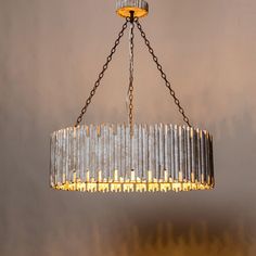 a chandelier hanging from the ceiling in a room with grey walls and wooden flooring