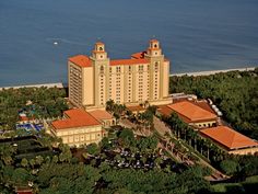 an aerial view of the resort and its surrounding grounds with cars parked in front of it