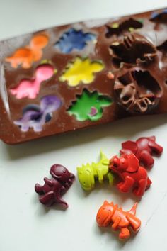 there are many small toy animals next to a chocolate tray with candy molds on it