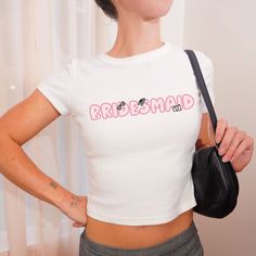 We love this fun, hand drawn Bridesmaid Baby Tee! This adult sized tee is soft and super comfy and is made of 52% cotton and 48% polyester for a luxurious lightweight stretch. The designs are printed with DTF which delivers a vivid, detailed design with a textured feel. See our Bride tee here: https://fizzcandydesigns.etsy.com/listing/1788900193 This tee is a perfect blend of coquette fashion and nostalgic Y2K vibes, making it a trendy addition to your casual wardrobe. Made with soft, comfortable material, it's ideal for everyday wear or for making a statement at your next gathering. Pair it with your favorite jeans or skirt for a cute and effortless look.  Note: these are custom items that are printed when ordered.  Items may be slightly different from the images in the listing. FABRICATI White Custom Print Top For Bachelorette Party, White Fitted T-shirt For Bachelorette Party, Fitted Graphic Print Top For Bachelorette Party, White Fitted Shirt For Bachelorette Party, White Fitted Top For Bachelorette Party, Fitted White Tops For Bachelorette Party, Balletcore Aesthetic, Trendy Bridesmaids, Bride Tee