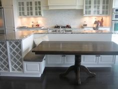 a large kitchen with white cabinets and an island table in front of the countertop