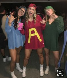 three girls posing for the camera with their arms in the air and one girl holding her phone