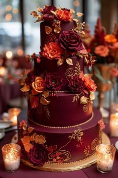 a purple wedding cake with red flowers and gold trimmings sits on a table surrounded by candles