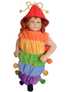 a small doll is wearing a rainbow colored outfit