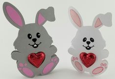 two paper rabbits with hearts sitting next to each other