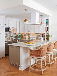 a kitchen with white cabinets and an island that has chairs around it in front of the counter