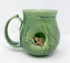 a green mug with a frog in it