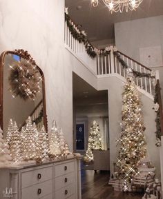 christmas trees and decorations are on display in the entryway