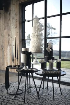 two tables with black and white decorations in front of a window