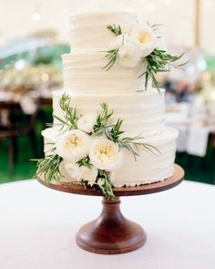 a wedding cake with white flowers and greenery