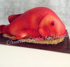 a red fish cake sitting on top of a wooden board