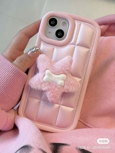 a person holding a pink cell phone case with a bow on it