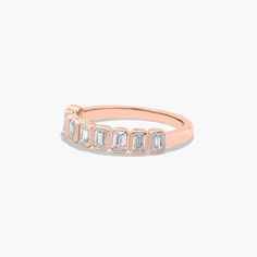 a rose gold ring with three baguettes on the side and two diamonds in the middle