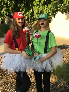 two girls dressed up as mario and luigi from mario kart, one holding flowers