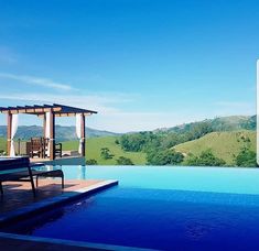 a large pool with a gazebo next to it on top of a hill in the distance