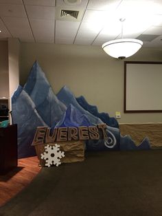 an office decorated for christmas with snowflakes on the floor and mountains painted on the wall