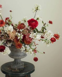 a vase filled with red and white flowers on top of a table