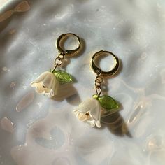 Handmade lily of the valley earrings to complete your Cottagecore aesthetic. 🌱 Materials: ✨ The flower is made from plastic beads, and earring hoops are made from 18k gold plated brass. Item care:  Avoid contact with water (remove earrings when showering and swimming). Remove during sleep to avoid damage.  Shipping: ✉️ All items will be packaged carefully in a bubble mailer envelope. A note and small gift will also be included with each purchase.  Made with love from Toronto ❤️ Earring Hoops, Cottagecore Aesthetic, Bubble Mailer, Plastic Beads, Small Gift, Lily Of The Valley, The Valley, Small Gifts, Jewelry Earrings Dangle