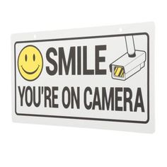 a white sign that says smile you're on camera