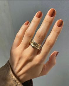 a woman's hand with a gold ring on her left wrist and two fingers in the foreground