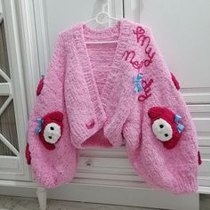 a pink teddy bear sweater hanging on a door