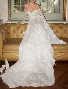 a woman in a wedding dress standing on a couch