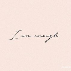 the word i am enough written in cursive handwriting on a pink background with black ink