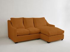 an orange sectional couch sitting on top of a white floor