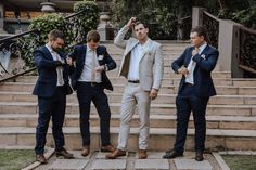 three men in suits are standing on some steps and one man is adjusting his tie