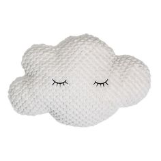 a white cloud pillow with eyelashes on it