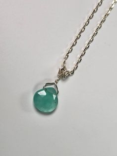 This Chalcedony Gemstone Pendant is amazing! The facets shine from every angle. The color is amazing! It lays nicely and is very dainty. The Gem is a bit over 10mm in size and has stunning color!! This stone has calming and stabilizing energy which helps increase the mental abilities, inner peace, and emotional honesty. It is a solid healing stone as well, protecting against infections and various health conditions. Chalcedony shields against negative outside influences that may lead to nightmare dreams. This stone opens a channel for better communication and helps verbalize our feelings the proper way. It increases life energy and promotes emotional balance, vitality, and fortitude. It makes us generous, kind, and friendly, always ready to perform good deeds. Elegant Faceted Briolette Emerald Necklace, Silver Faceted Round Pendant Jewelry, Elegant Silver Faceted Beads Gemstones, Sterling Silver Briolette Crystal Necklace As A Gift, Sterling Silver Briolette Crystal Necklace For Gift, Dainty Silver Pendant Emerald Necklace, Dainty Silver Faceted Necklace, Dainty Silver Emerald Pendant Necklace, Elegant Silver Gemstones With Faceted Beads