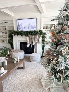 a living room decorated for christmas with stockings on the fireplace mantel and garlands