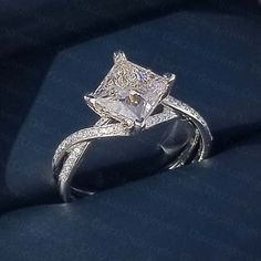 a diamond engagement ring on top of a blue cloth