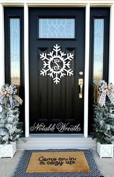 the front door is decorated with snowflakes and evergreens