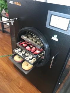 a machine that has some donuts in it and is on top of a wooden floor