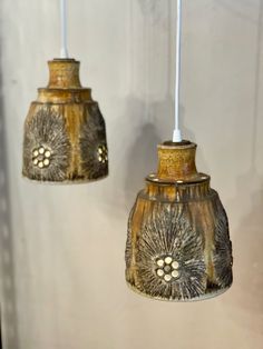 two hanging light fixtures with flowers on them