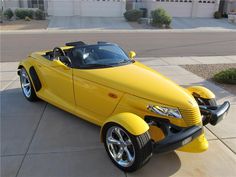 a yellow convertible car parked in front of a building