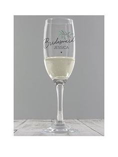 a wine glass filled with white wine on top of a table