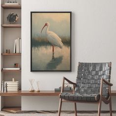 a large white bird standing in the water near a book shelf with books on it