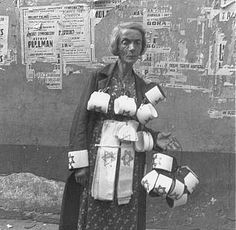 an old black and white photo of a woman holding several items