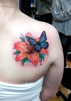 a woman with a butterfly tattoo on her back shoulder and flower in the foreground