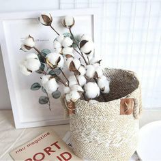 a vase with cotton flowers in it next to a card