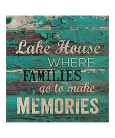 the lake house where families go to make memories is painted on an old wood plank