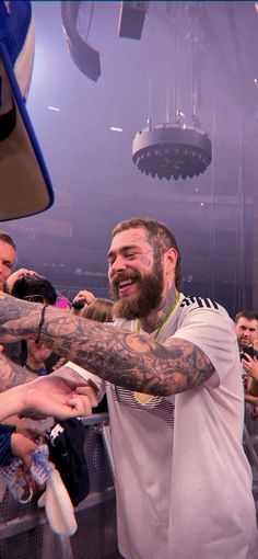 a man with tattoos holding a baseball bat