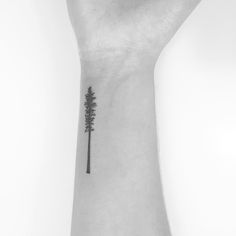 a small tree tattoo on the wrist is shown in this black and white photo,