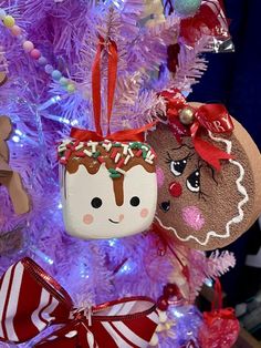 christmas ornaments are hanging from the tree in front of a purple christmas tree with white and red decorations