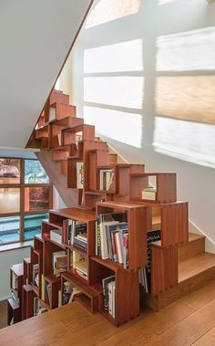 the stairs are made out of bookshelves and wooden shelves with books on them